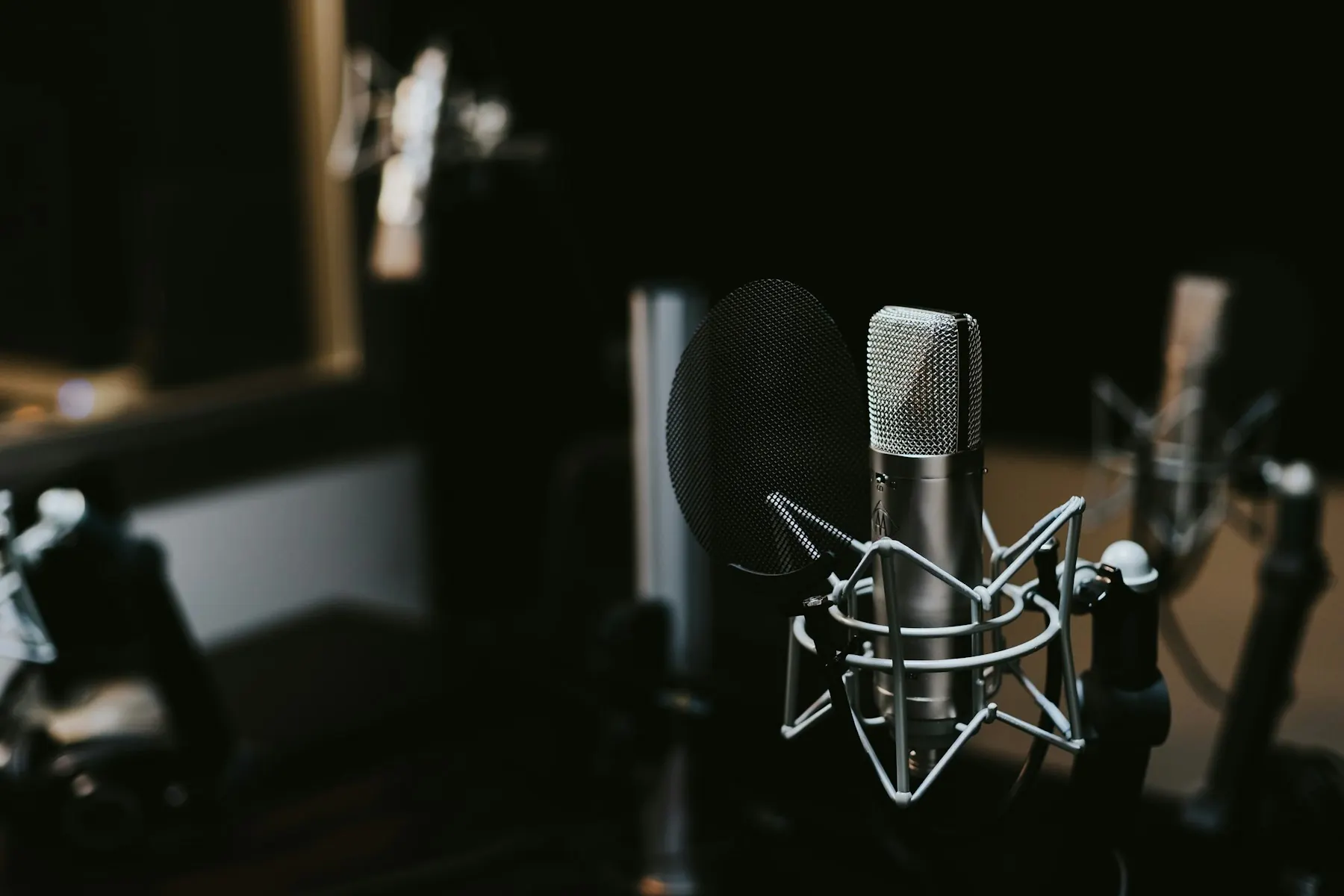 A silver microphone in a recording setting. Conceptual podcast imagery.