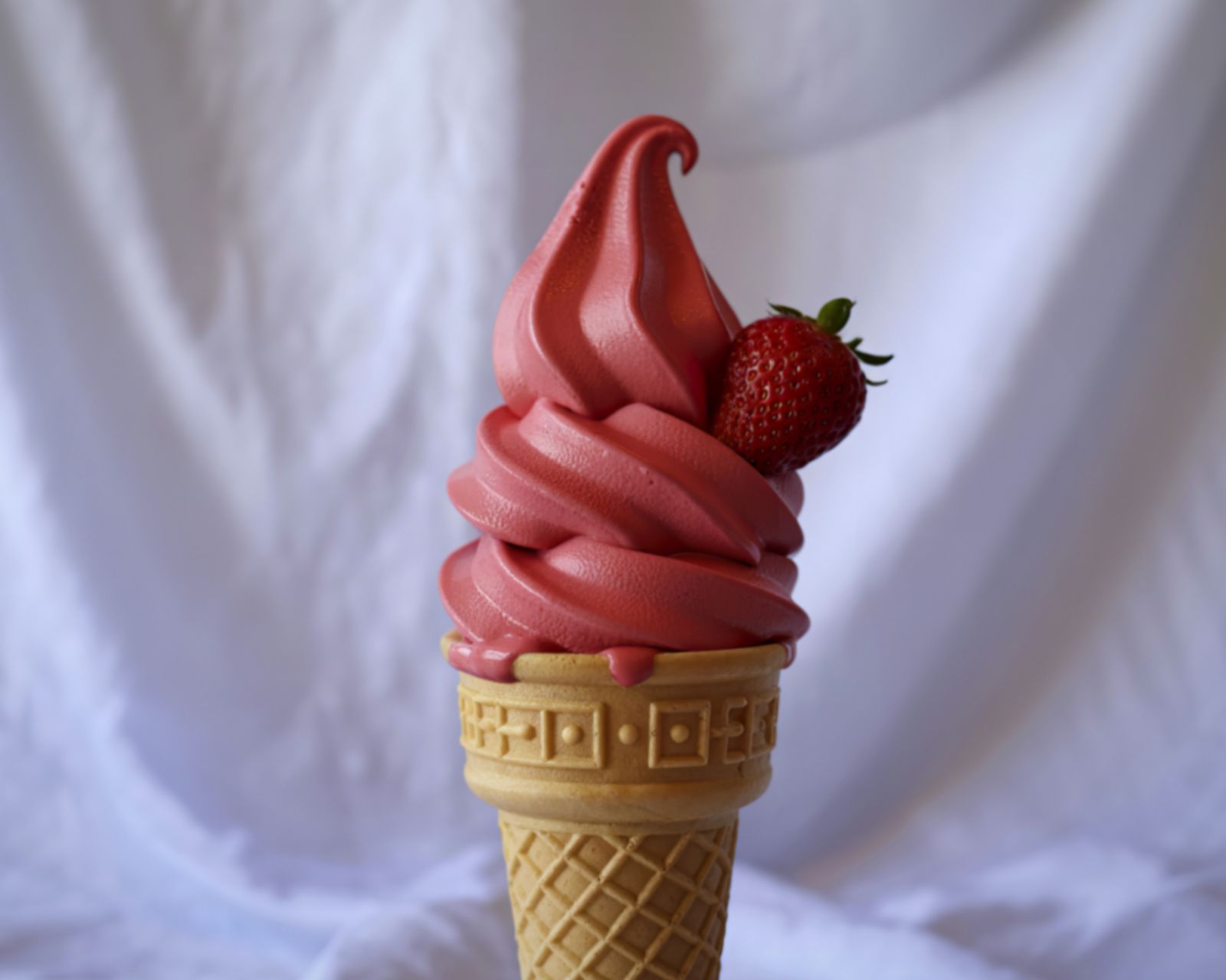 A strawberry soft-serve ice cream cone. Temporary concept photography.