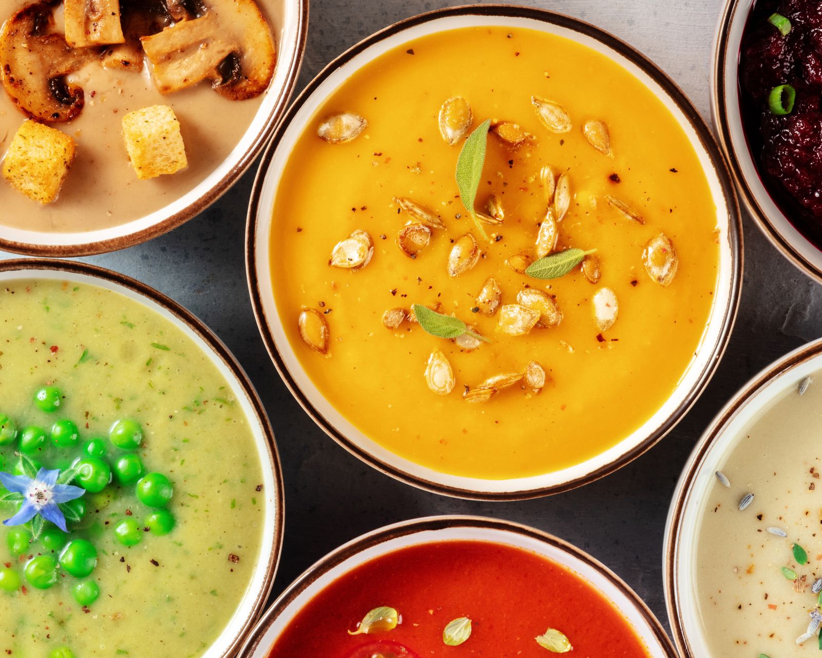 Several bowls of soup seen from above. Temporary concept photography.