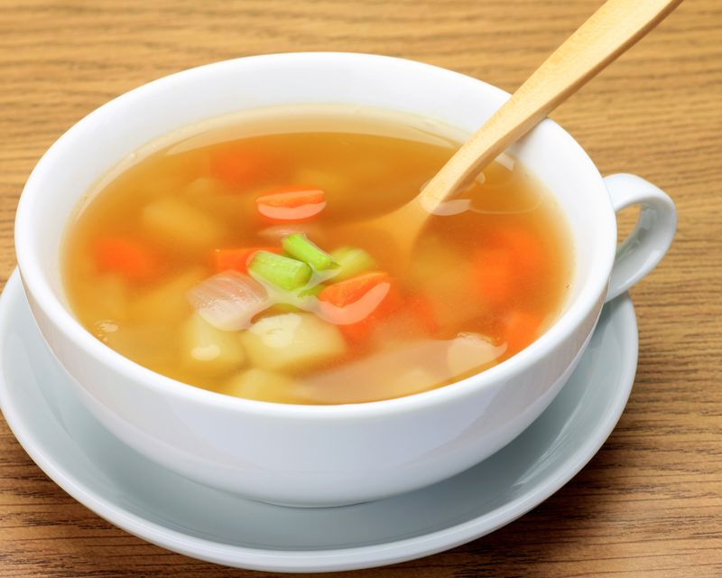 A vegetable broth with diced vegetables. Temporary concept photography.
