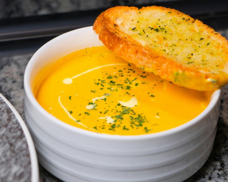 A creamy soup with toasted bread on the rim. Temporary concept photography.