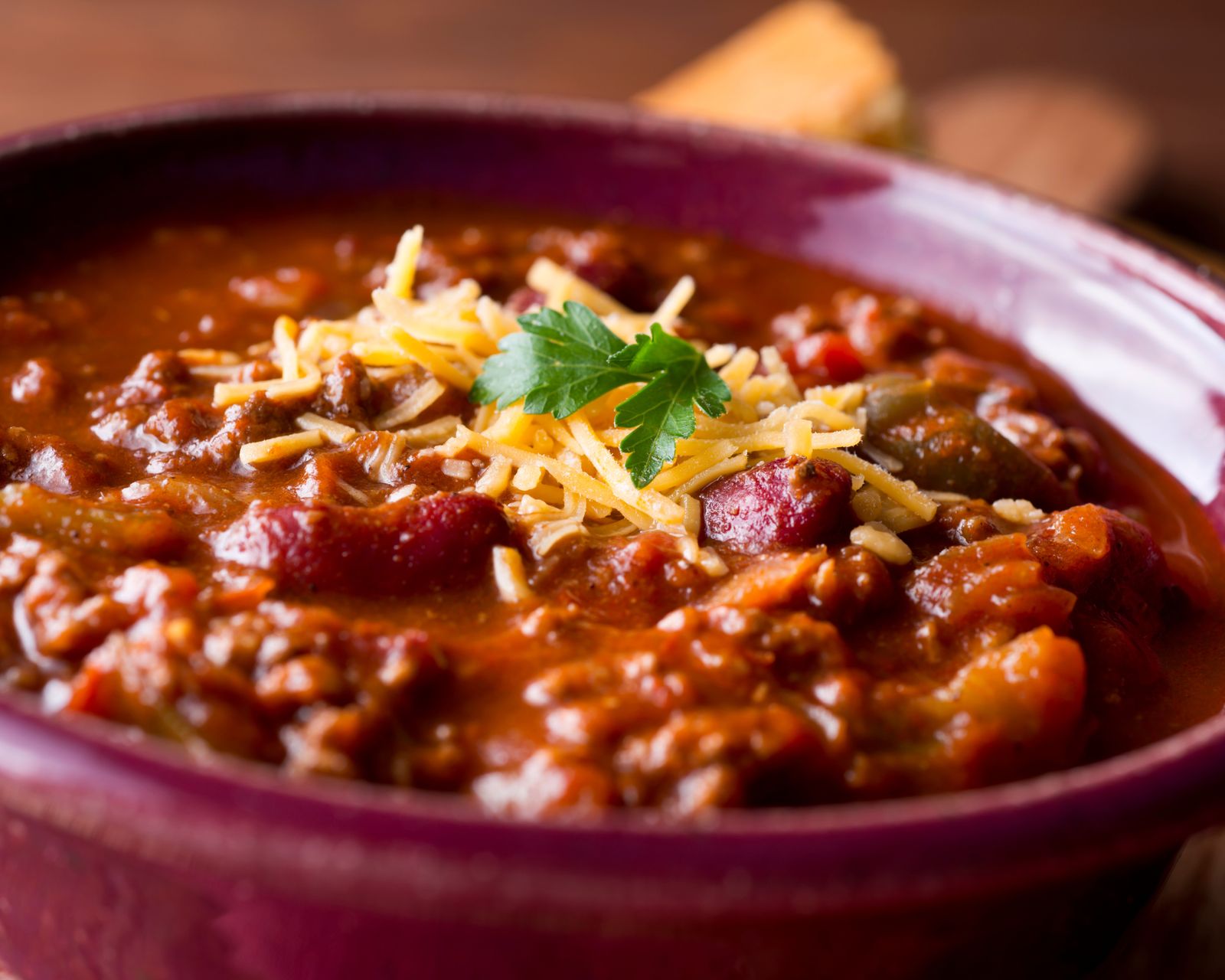 A bowl of chili topped with shredded cheese. Temporary concept photography.