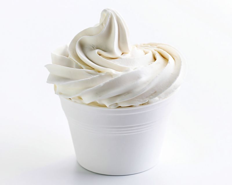 White soft-serve ice cream in a cup. Temporary concept photography.