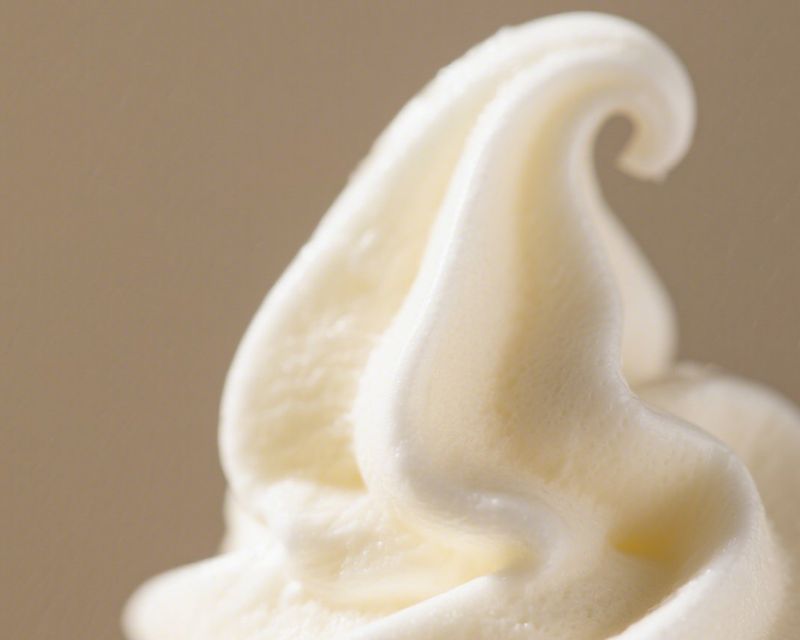 A close-up of a soft-serve ice cream swirl. Temporary concept photography.